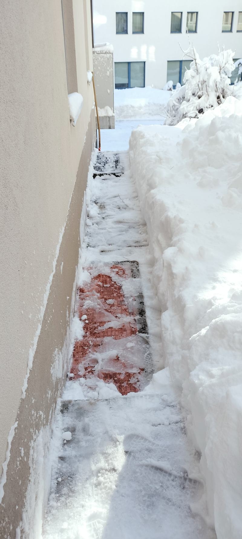 Freigeräumter Weg entlang der Hausfassade