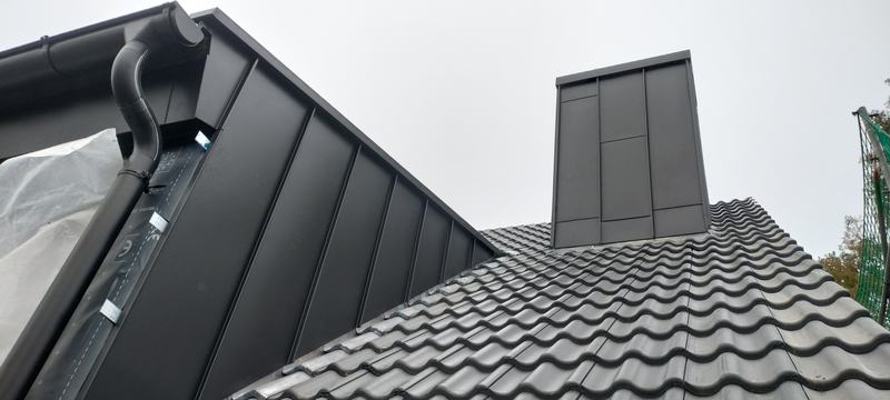 Blechverkleidung an Gaube und Kamin auf einem Ziegeldach