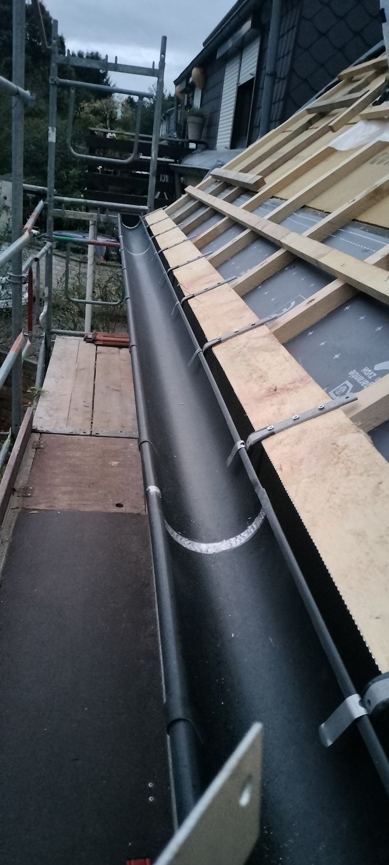 Neue Dachrinne aus Anthrazink während der Montage