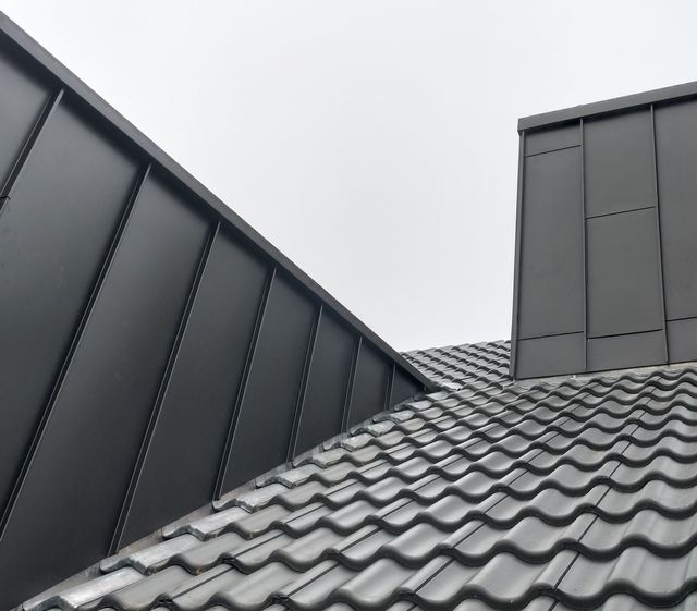 Blechverkleidung an Gaube und Kamin auf einem Ziegeldach
